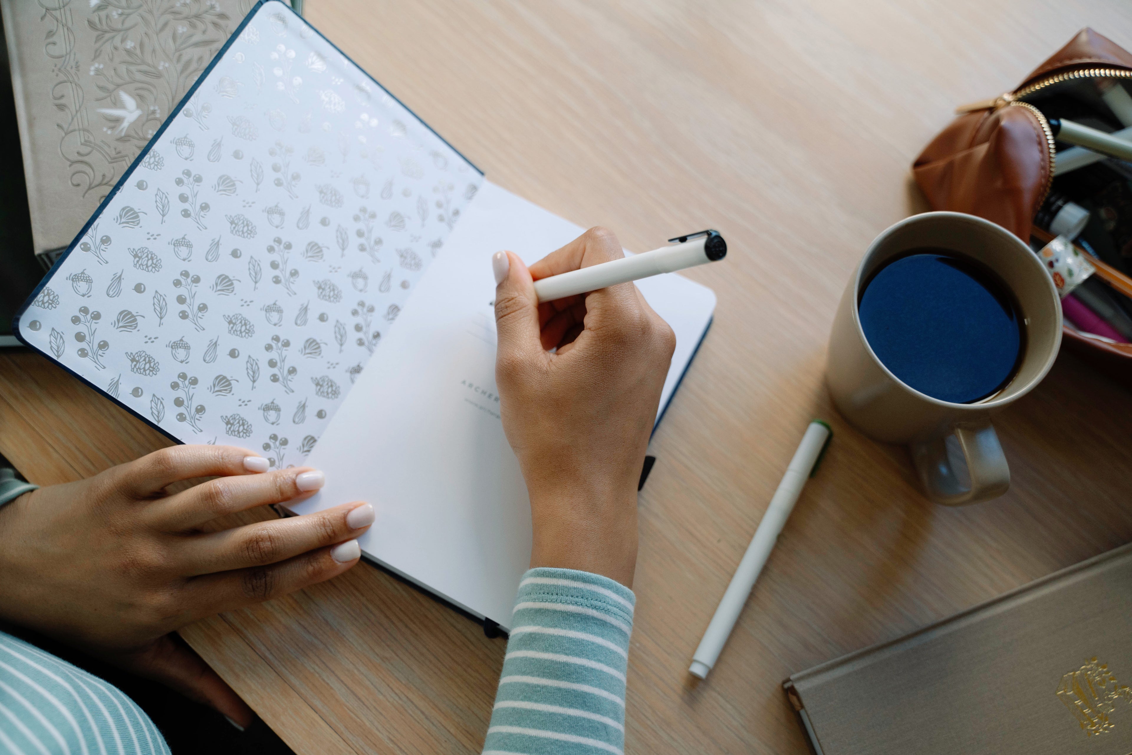 A cozy moment of journaling surrounded by beautifully detailed notebooks, coffee, and soft natural light. These images capture the quiet joy of creativity and reflection.