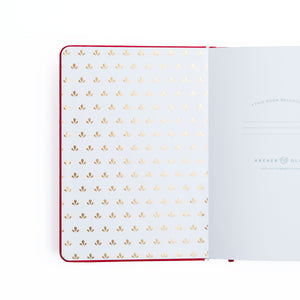 Open notebook with gold dot pattern on white pages, brand 'Archer & Olive' visible.