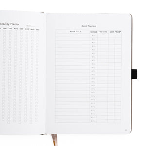 Notebook with reading and book tracker pages on a white background