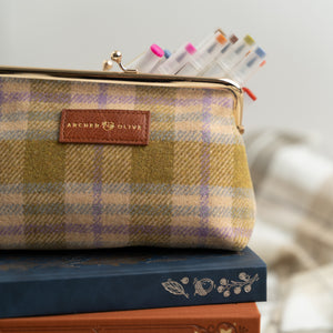 Plaid pouch with colorful markers on top of books, featuring 'Archer & Olive' brand.